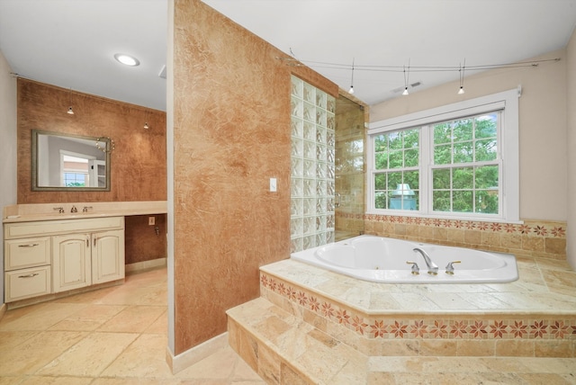 bathroom featuring vanity and tiled tub