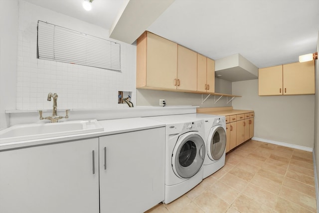 laundry room featuring cabinets, light tile patterned flooring, sink, and washer and clothes dryer