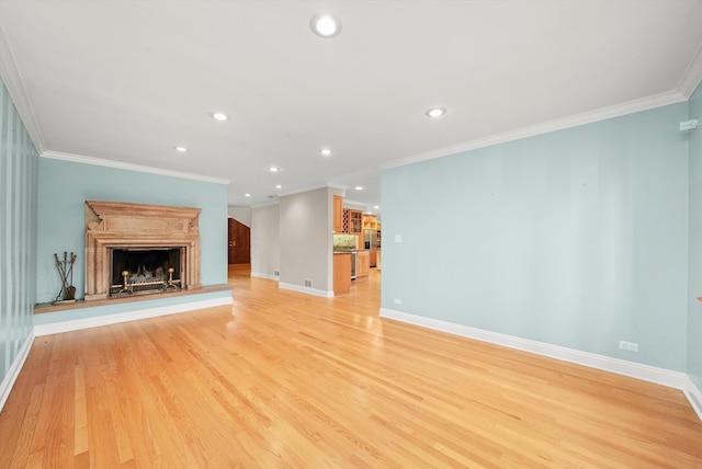 unfurnished living room featuring ornamental molding and light wood-type flooring