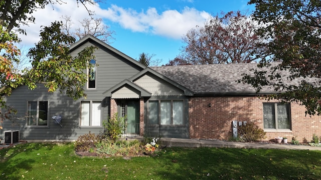 view of front of home with central air condition unit and a front yard