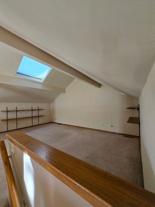 bonus room with carpet flooring and vaulted ceiling with skylight