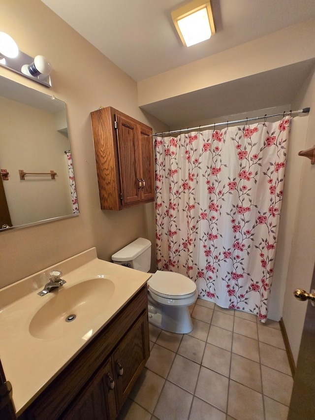 bathroom with toilet, vanity, and tile patterned floors