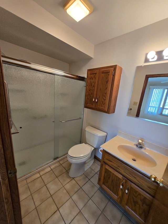 bathroom with vanity, walk in shower, tile patterned floors, and toilet