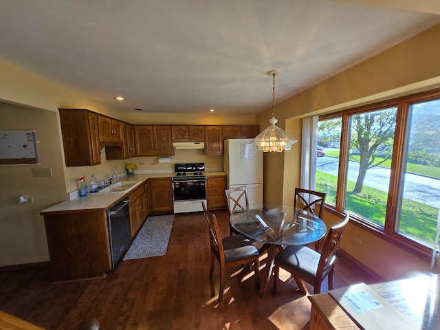 kitchen with a notable chandelier, sink, dark hardwood / wood-style floors, pendant lighting, and white appliances