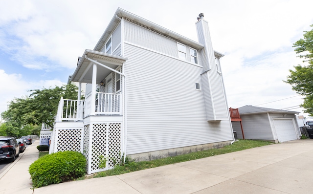 view of side of home with a porch and an outdoor structure