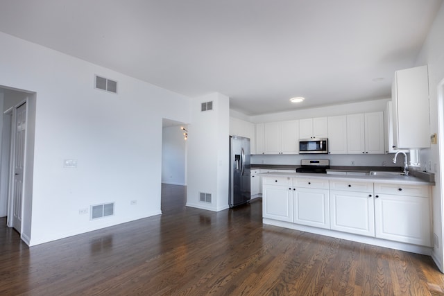 kitchen featuring white cabinets, appliances with stainless steel finishes, sink, and dark hardwood / wood-style flooring