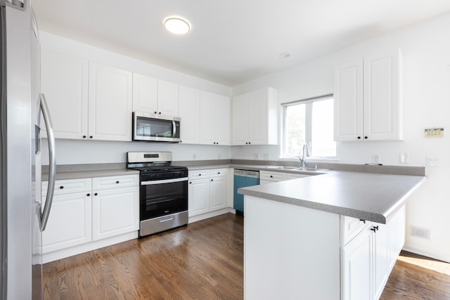 kitchen featuring kitchen peninsula, appliances with stainless steel finishes, dark hardwood / wood-style floors, and white cabinets