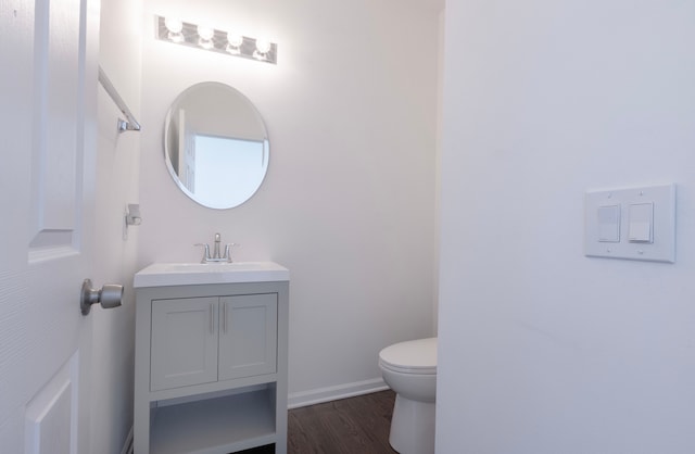 bathroom with wood-type flooring, vanity, and toilet