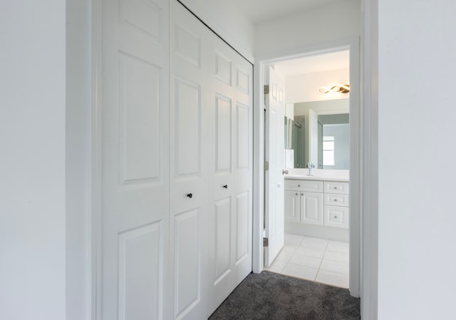 hallway featuring sink and light tile patterned floors