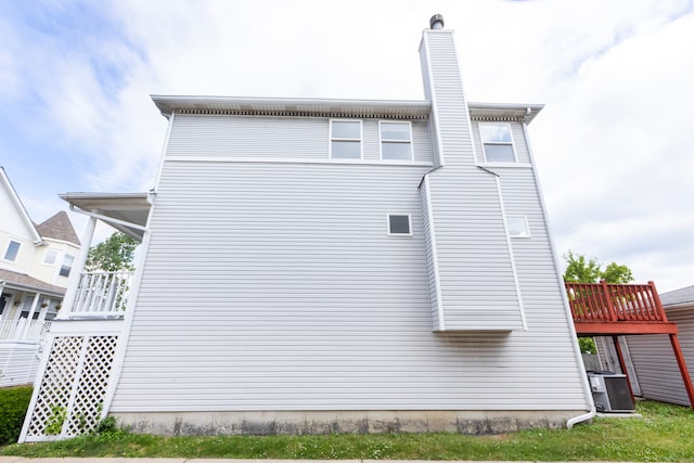 view of side of property featuring central AC unit and a deck