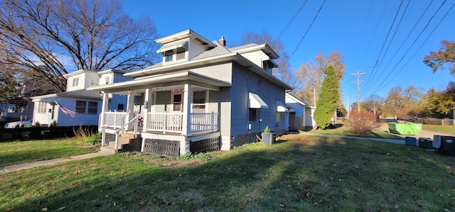 bungalow-style home featuring covered porch, central air condition unit, and a front yard