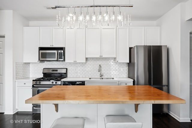 kitchen featuring white cabinetry, appliances with stainless steel finishes, sink, and dark hardwood / wood-style floors