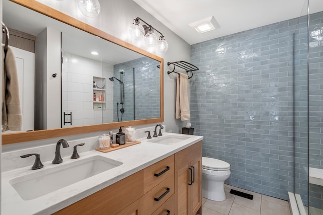 bathroom featuring tile walls, a shower with door, vanity, tile patterned flooring, and toilet