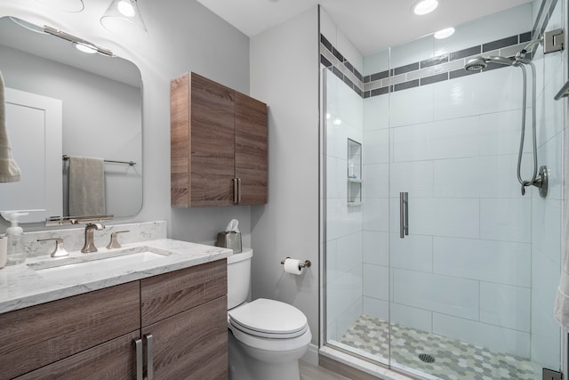 bathroom featuring vanity, toilet, a shower with door, and wood-type flooring