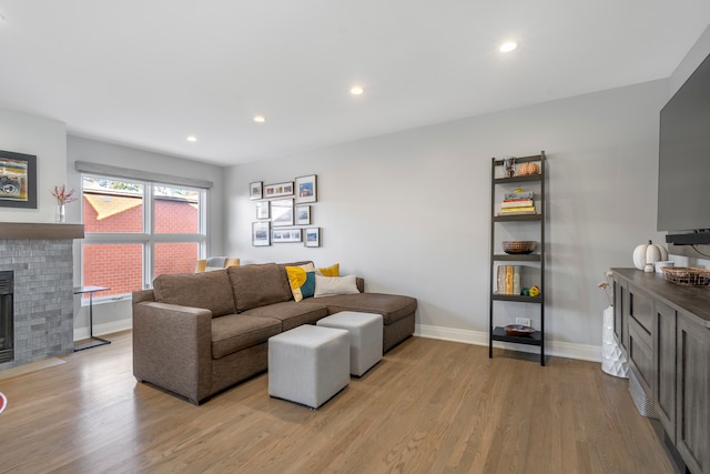 living room with a brick fireplace and light hardwood / wood-style flooring