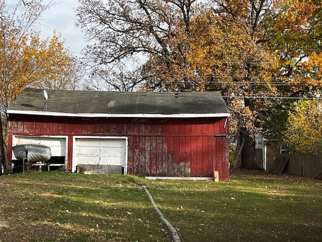 view of outdoor structure featuring a garage and a lawn