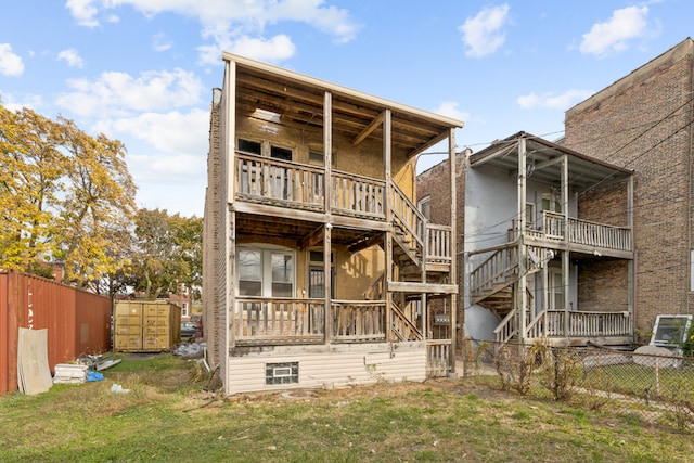 back of house featuring a balcony and a yard