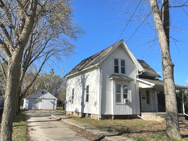 view of front facade with an outbuilding, a garage, and covered porch