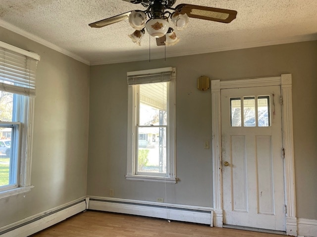 foyer entrance featuring ceiling fan, a baseboard radiator, a textured ceiling, hardwood / wood-style flooring, and ornamental molding