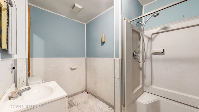 bathroom with walk in shower, vanity, and tile walls