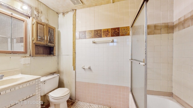 full bathroom featuring tile patterned floors, vanity, combined bath / shower with glass door, and toilet