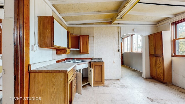 kitchen featuring vaulted ceiling with beams and sink