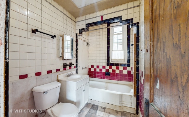 bathroom with a bath, vanity, toilet, and tile walls