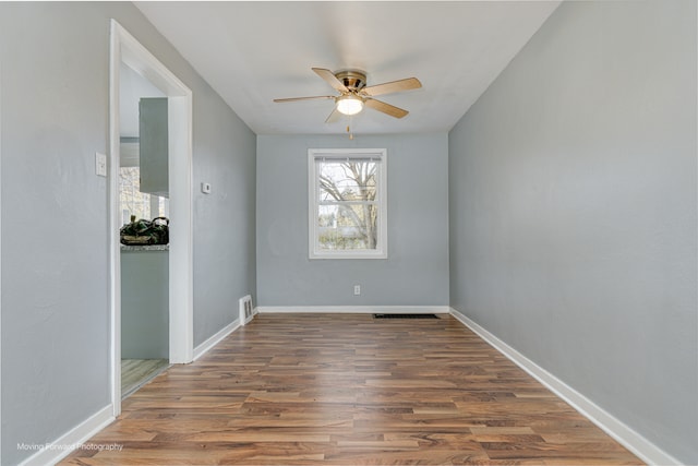 spare room with ceiling fan and dark wood-type flooring