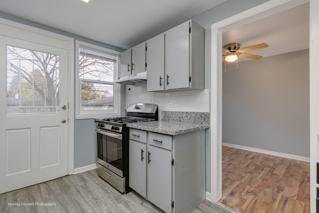 kitchen featuring ceiling fan, light wood-type flooring, backsplash, and stainless steel gas range