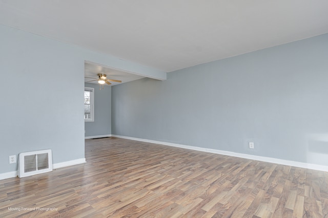 spare room with ceiling fan, beam ceiling, and light wood-type flooring