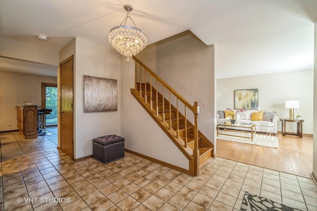 stairway featuring tile patterned floors and an inviting chandelier