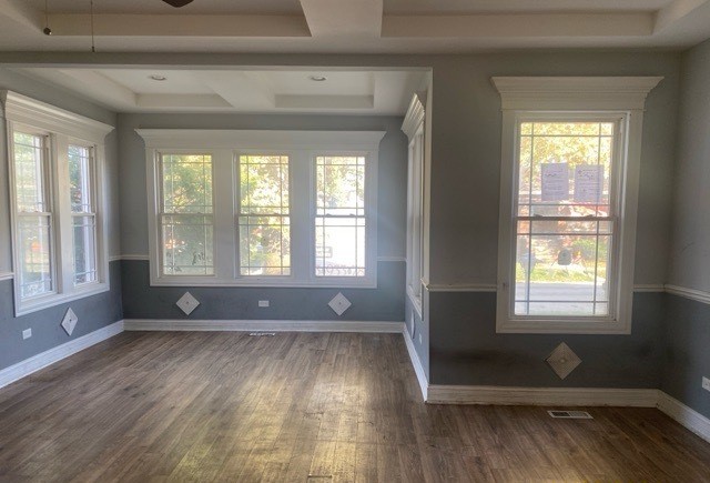 empty room with ceiling fan, dark hardwood / wood-style floors, and a raised ceiling