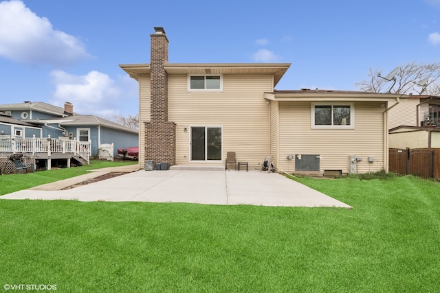 rear view of property featuring a lawn and a patio