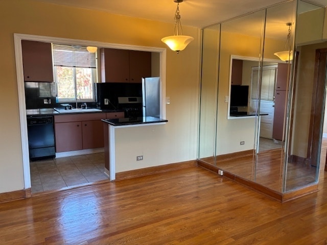 kitchen featuring dishwasher, light hardwood / wood-style floors, sink, and stainless steel fridge