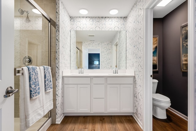 bathroom with vanity, hardwood / wood-style flooring, toilet, and a shower with door