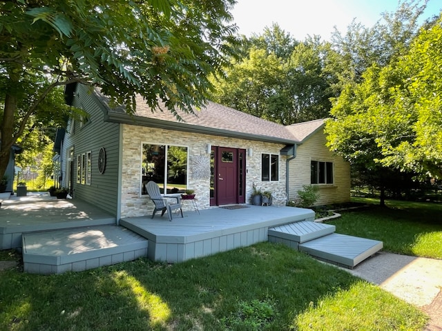 back of property featuring a lawn and a deck