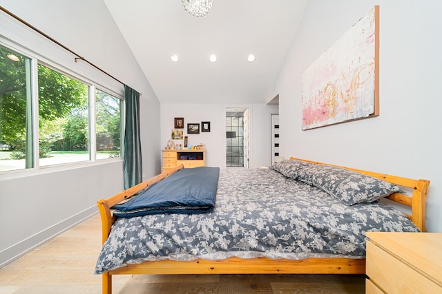 bedroom featuring light wood-type flooring and vaulted ceiling