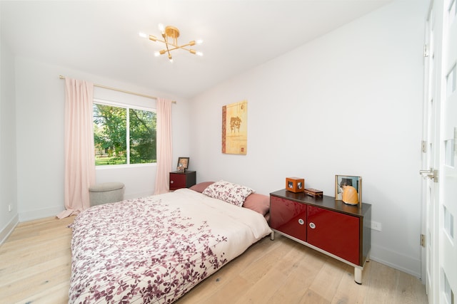 bedroom with a chandelier and hardwood / wood-style floors