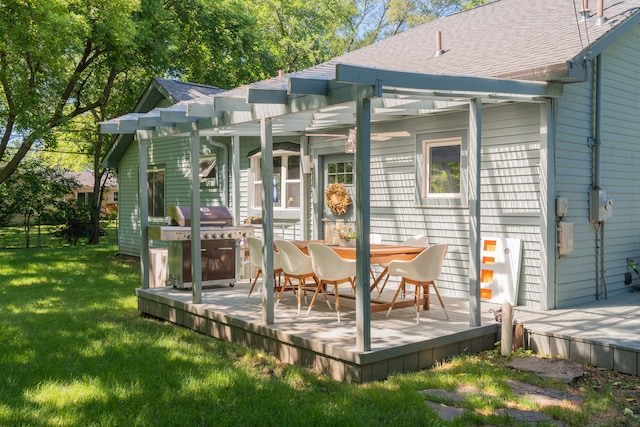 rear view of house with a wooden deck, a pergola, and a lawn