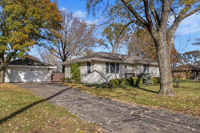 single story home featuring an outbuilding, a front yard, and a garage