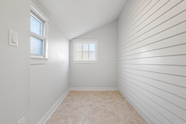 unfurnished room with vaulted ceiling