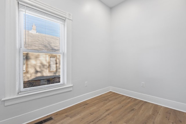 unfurnished room with hardwood / wood-style flooring