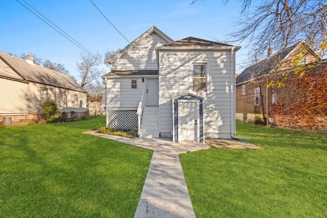 back of house with a lawn and an outdoor structure