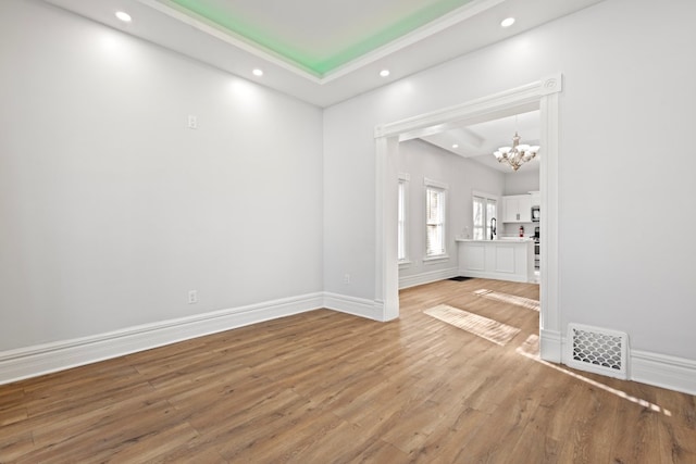 empty room featuring hardwood / wood-style floors and an inviting chandelier