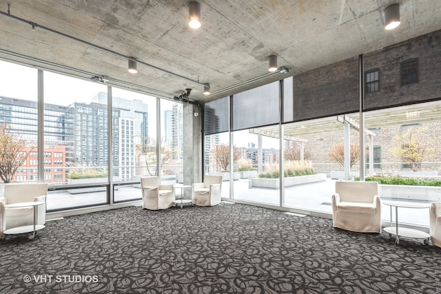 unfurnished sunroom with rail lighting and a wealth of natural light