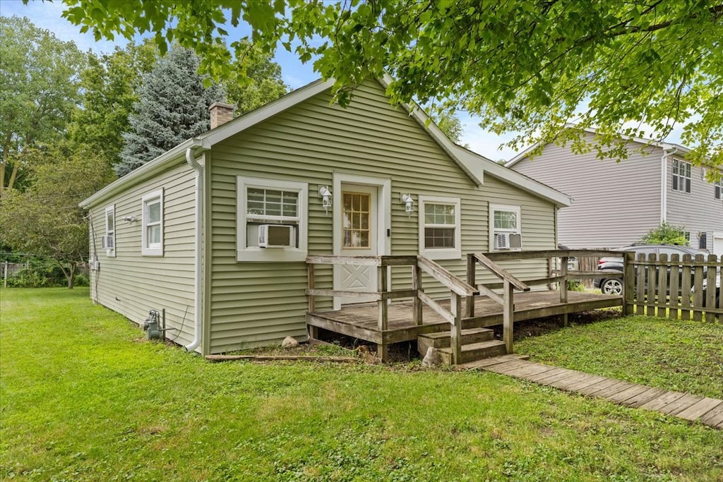 rear view of house with cooling unit, a lawn, and a deck