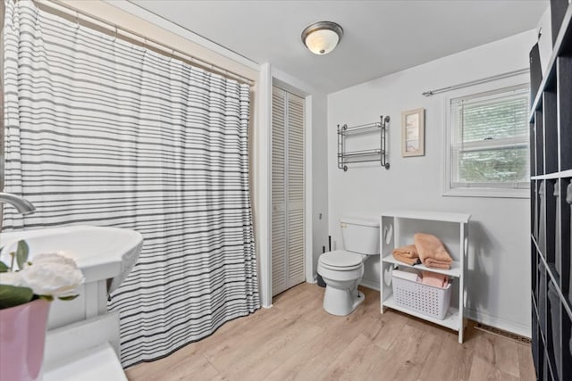 bathroom with hardwood / wood-style floors and toilet