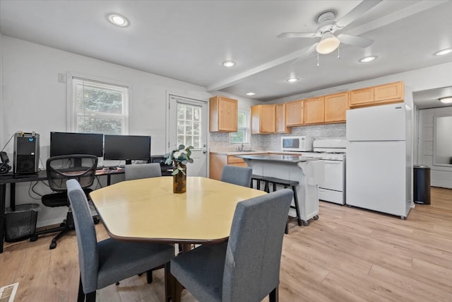 dining space featuring light wood-type flooring, sink, and ceiling fan