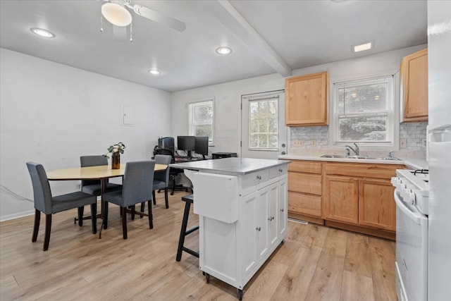 kitchen featuring light hardwood / wood-style floors, a breakfast bar, white range, a center island, and decorative backsplash