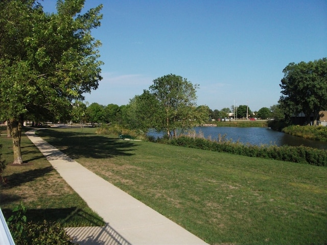 view of property's community featuring a lawn and a water view